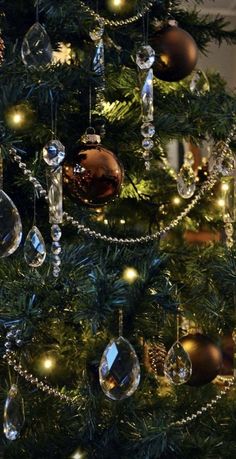 a christmas tree with ornaments hanging from it's branches and lights on the top