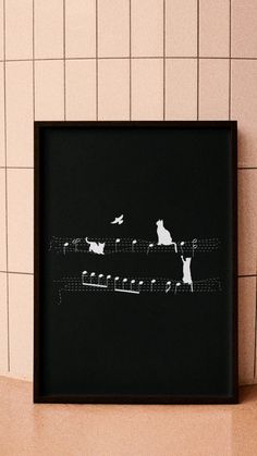 a black and white photo with cats sitting on top of piano keys in front of a tiled wall