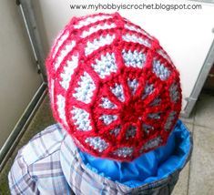 a red and white crocheted hat sitting on top of a person's head