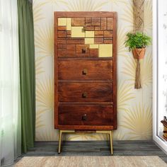 a tall wooden dresser sitting in front of a window next to a potted plant