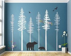 a bear and two cubs in the woods wall decal on a blue wall with white trees