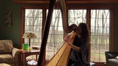 a woman is playing the harp in her living room