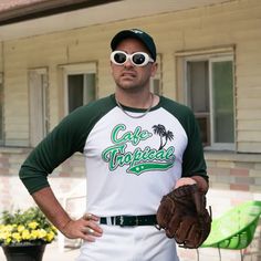 a baseball player is standing in front of a house with his hands on his hip