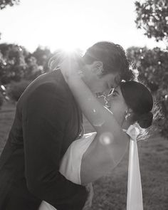 a bride and groom kissing in the sun