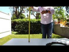 a man standing in front of a white table with a measuring tape on top of it