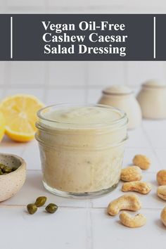 vegan oil - free cashew caesar salad dressing in a glass jar surrounded by nuts and lemons