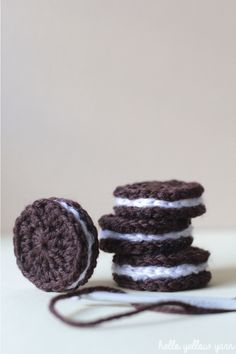 three crocheted cookies sitting next to each other on top of a white table