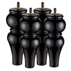 four black vases are stacked on top of each other in the shape of an apple