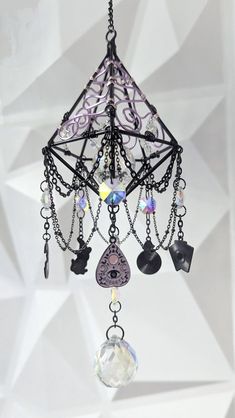 a chandelier hanging from the ceiling with beads and charms on it's chain