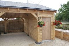 a wooden shed with flowers on the roof