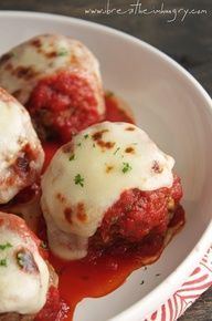 some meatballs covered in sauce and parmesan cheese