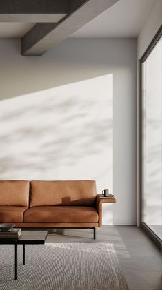 a living room with a brown leather couch and coffee table in front of a large window