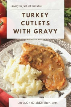 turkey cutlets with gravy on a plate next to mashed potatoes and tomatoes