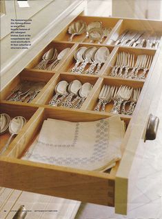 an open drawer with silverware in it