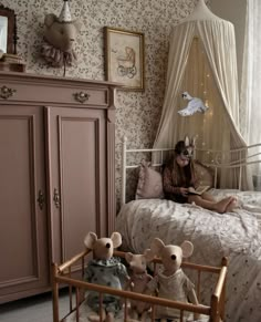 a woman sitting on top of a bed next to stuffed animals