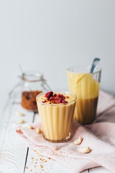 two glasses filled with food sitting on top of a table