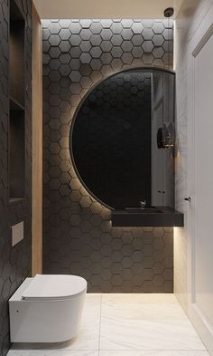 a modern bathroom with hexagonal tiles on the wall and round mirror above the toilet