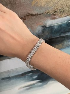 "Valentine's Day is around the corner. Is there anything that catches your eye?  Elegant Jewelry - everybody deserves that little elevation to their look without breaking their bank and this CZ Baguette bracelet is the most elegant addition yet!  Just added and currently on sale for the 4th of July weekend!  This tennis bracelet is standard size. It is made of 925 sterling silver,  featuring a setting of high quality simulated diamonds. Sizing: This cubic zirconia baguette bracelet comes in a standard size that aims to fit a range of wrist sizes. It is featured on a 6\" wrist.   Materials:  - Sterling Silver  - High Quality Simulated Diamonds (known as: Cubic Zirconia, CZ) Care Details: It is advised to wear it with care for the longevity of the piece. It is advised for it to remain away f Dazzling Silver Baguette Cut Diamond Bracelet, Modern Tennis Bracelet With Baguette Diamonds For Wedding, Silver Baguette Diamond Tennis Bracelet For Wedding, Dazzling Cubic Zirconia Baguette Cut Tennis Bracelet, Modern Wedding Tennis Bracelet With Baguette Diamonds, White Gold Bracelet With Baguette Diamonds And Cubic Zirconia, Modern Tennis Bracelet With Baguette Diamonds And Cubic Zirconia, Silver Tennis Bracelet With Baguette Diamonds, White Diamond Bracelet With Baguette Diamonds For Gift