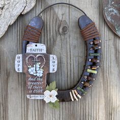 a wreath made out of leather and beads on a wooden surface with a tag attached to it