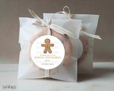 a bag filled with cookies sitting on top of a white tablecloth next to a tag that says merry christmas