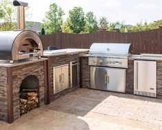 an outdoor bbq grill with two ovens on the side and a fire pit in the middle