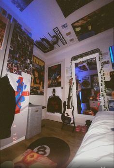 a bedroom with guitars and posters on the walls