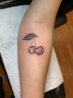 small cherries tattoo on the left arm