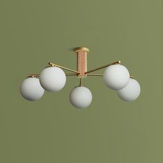 a chandelier with five white balls hanging from it's brass finish fixture