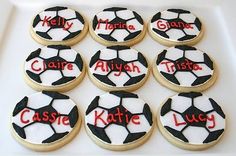 cookies decorated with soccer balls and name written on them are sitting on a white platter