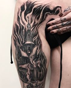 a woman's thigh with a black and white tattoo on her leg that has a castle in it