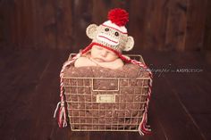 a newborn baby wearing a knitted sock monkey hat