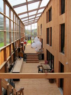 the inside of a building with lots of windows and wooden flooring on both sides