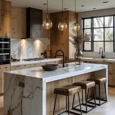 a kitchen with marble counter tops and stools next to an island in the middle