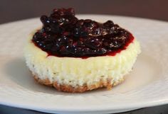 a small cheesecake with blueberry topping on a white plate