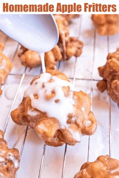 a spoon drizzling icing onto some pastries on a cooling rack