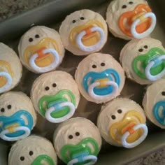 baby pacifier cupcakes sitting in a box on the floor with their faces painted to look like ducks