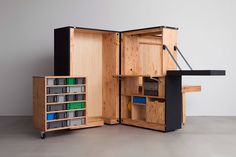 an open wooden cabinet with many drawers and shelves on wheels is shown in this image