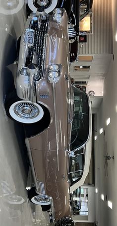 an old car is parked in a building with many mirrors on it's sides