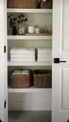 an open closet with towels and baskets in it