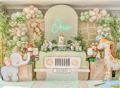 a baby's first birthday party with an elephant theme and safari animals on the wall