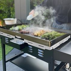 a man cooking food on top of a grill