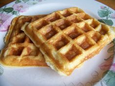 two waffles sitting on top of each other on a white plate with flowers