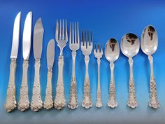 an assortment of silverware including forks, knives and spoons on a blue background