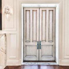 an open door in a white room with wood floors