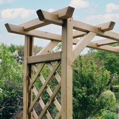 a wooden trellis in the middle of a garden