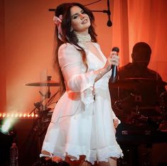 a woman in a white dress holding a microphone