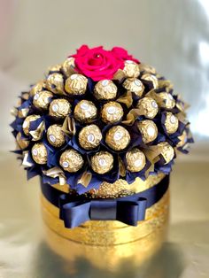 a bouquet of chocolates and a rose on top of a gold tin canister