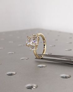 a diamond ring sitting on top of a piece of metal