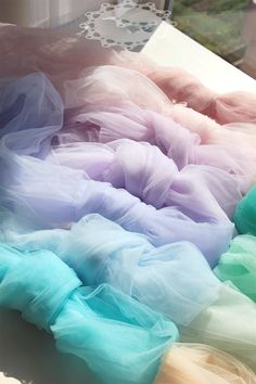 there are many different colored tulle skirts on the window sill