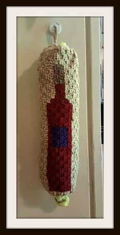 a wine bottle hanging on the wall in front of a door with a keychain attached to it